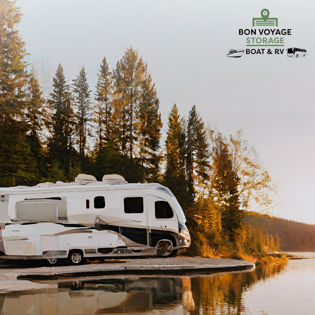 White RV at the edge of a river at sunset